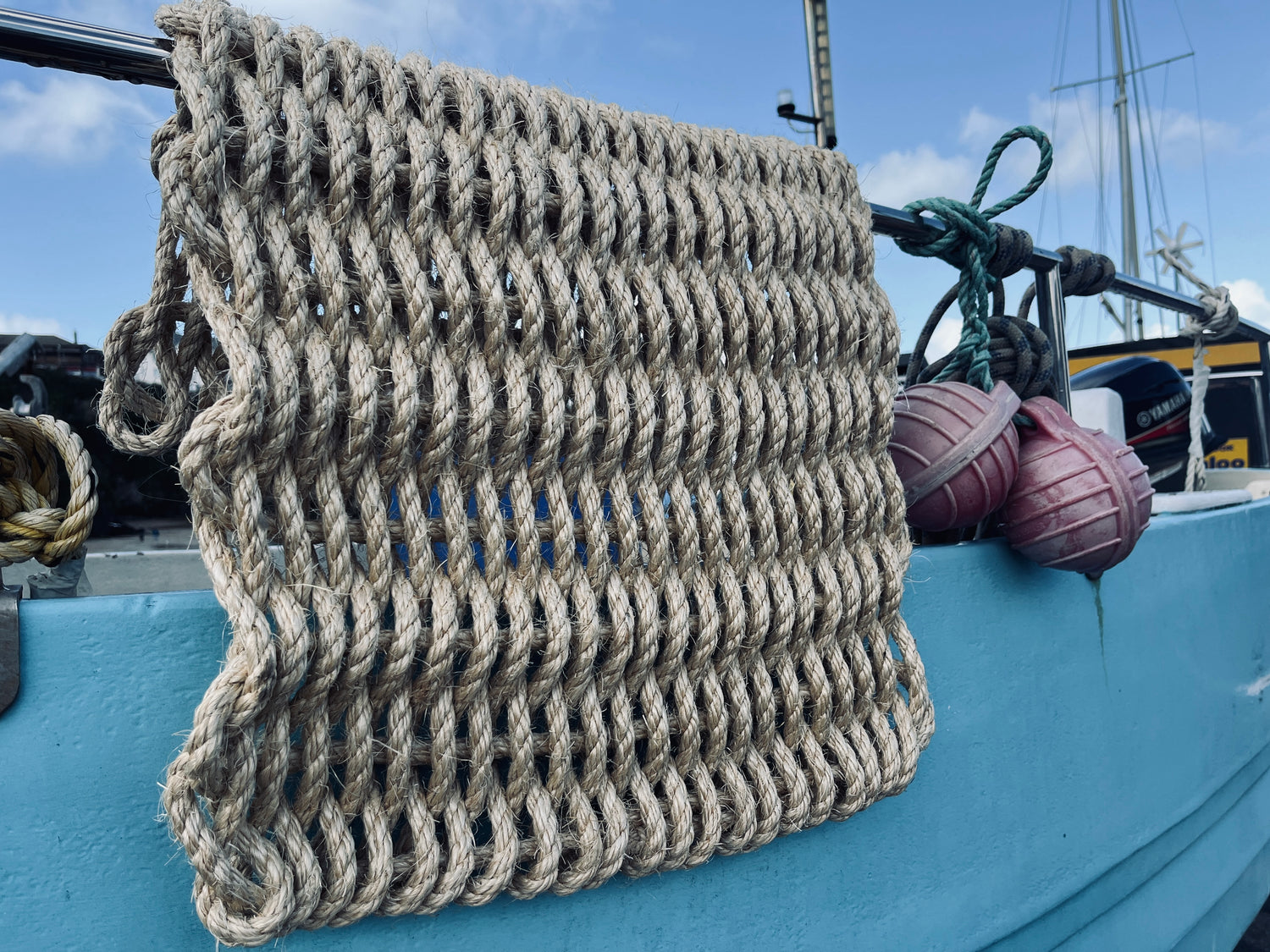 Woven rope mat on a boat with a blue background.