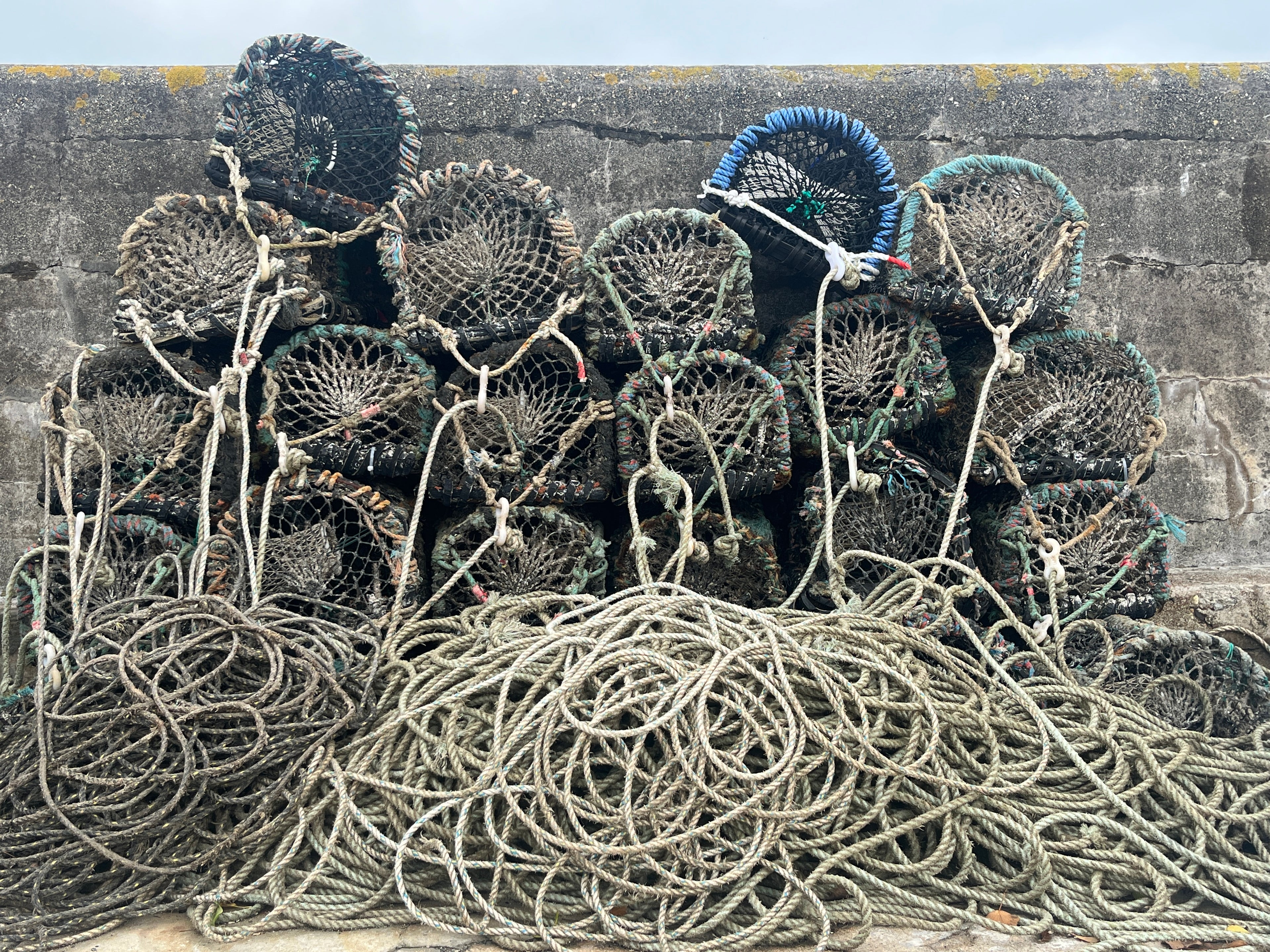 Stacked crab pots and fishing rope in Newquay harbour, the source of our reclaimed materials.